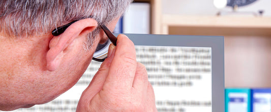 Hombre usando sus lentes lupa Big Vision para ver la computadora.