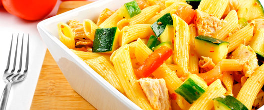 Ensalada de pollo con pasta, queso parmesano y cebollín.