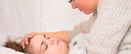 Mamá tranquilizando a su hija por un episodio de epilepsia nocturna.