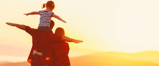 Imagen de una familia frente al amanecer.