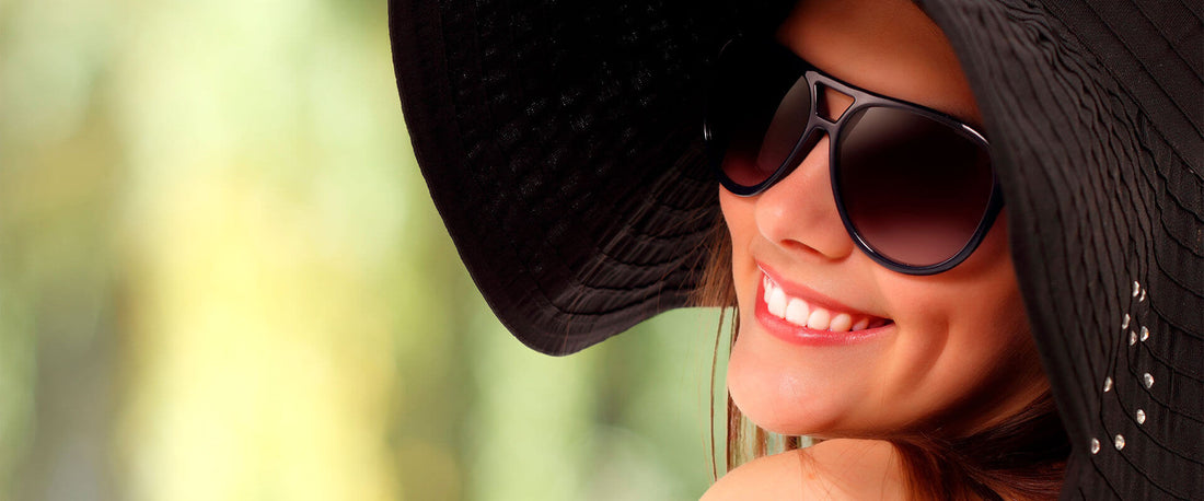 Mujer sonriendo, usando lentes de sol en verano