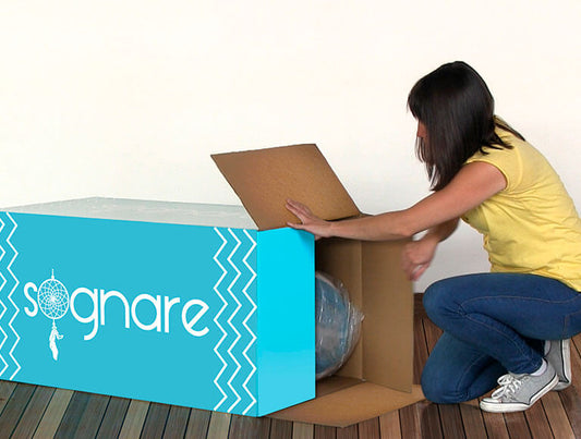 Mujer sacando el Colchón Sognare de su caja.