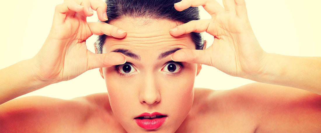 Mujer viéndose al espejo previniendo los signos de la edad con DermaWand.