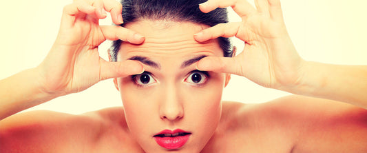 Mujer viéndose al espejo previniendo los signos de la edad con DermaWand.