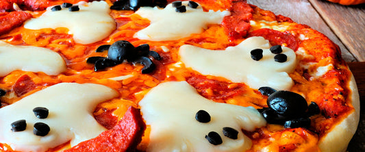Pizzas para halloween decoradas con aceitunas en forma de araña y queso en forma de fantasma.