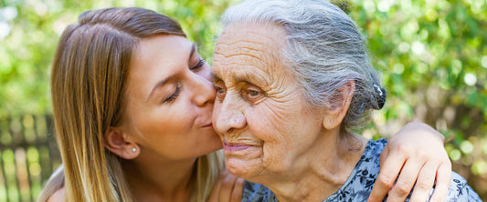 Mujer joven besando una mujer de la tercera edad o abuela