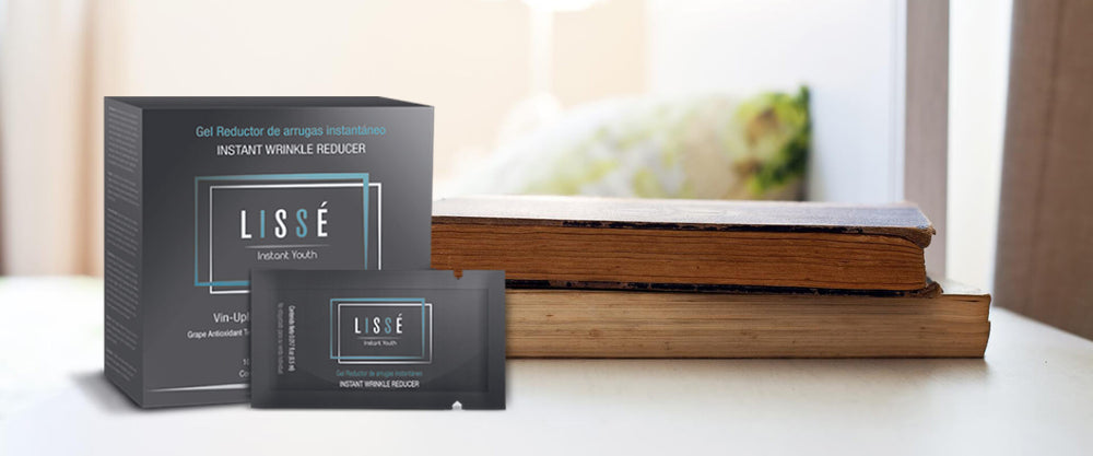 Varios sobres del producto de belleza Lissé sobre una mesa con libros.