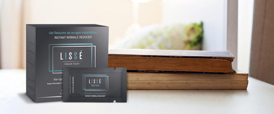 Varios sobres del producto de belleza Lissé sobre una mesa con libros.