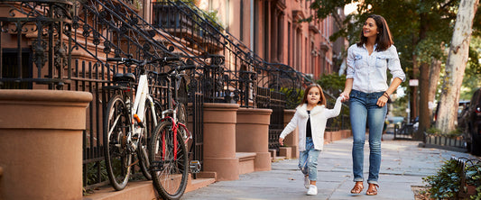 Mamá e hija caminando por la calle.