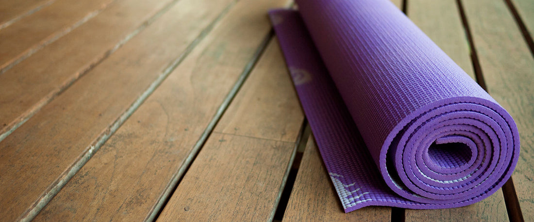 Tapete de yoga para la cintura, enrollado en el piso.