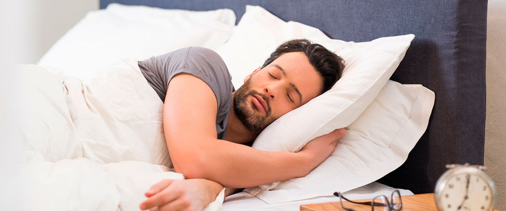 Hombre durmiendo placenteramente sobre almohadas soñare.