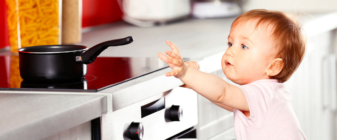 Bebé tratando de agarrar algo caliente de la cocina.
