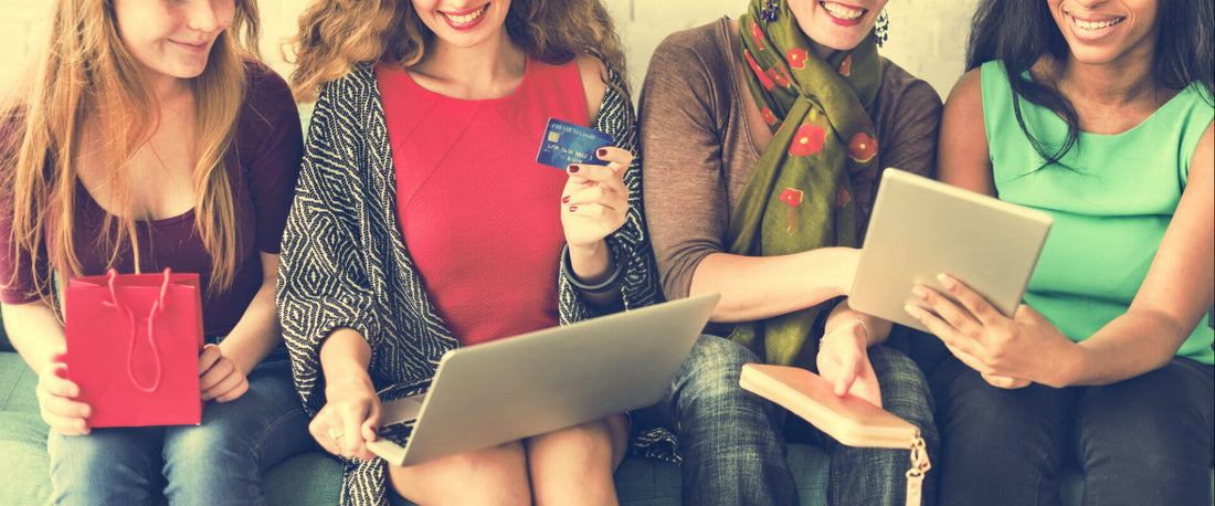 Mujeres sentadas juntos su computadora compranod