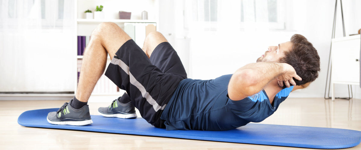Hombre haciendo abdominales en su casa