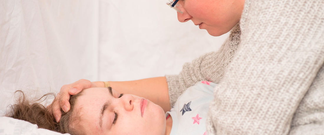 Mamá tranquilizando a su hija por un episodio de epilepsia nocturna.