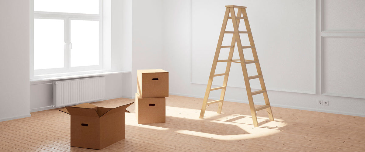 Cajas y escaleras en departamento nuevo con ventanal.