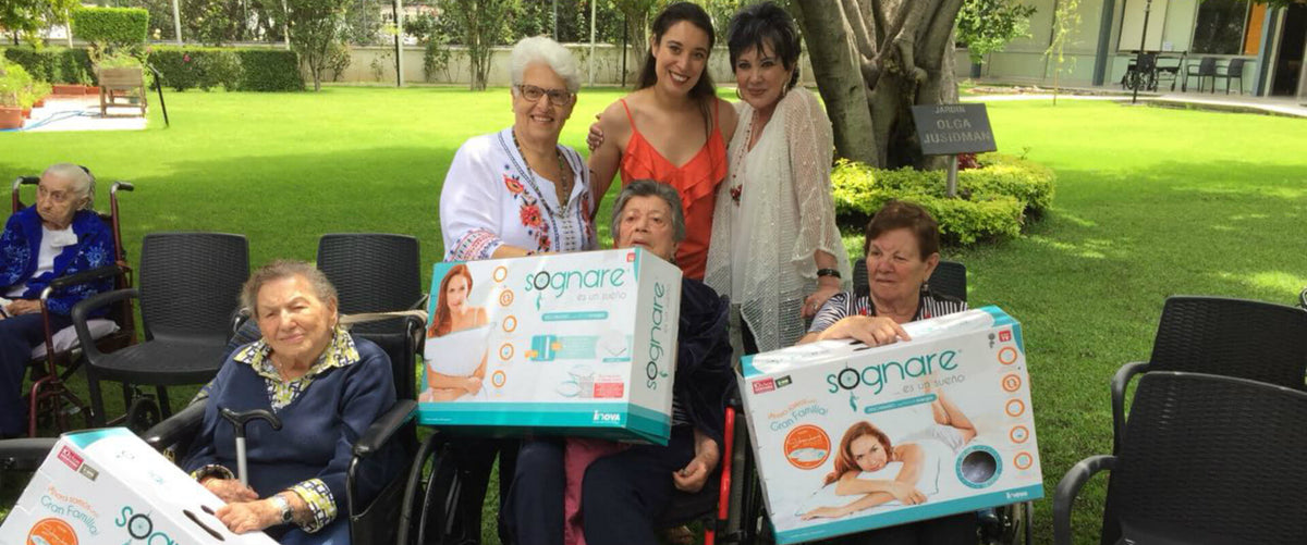 Representantes de Grupo Inova y Fundación Inova entregando almohadas sognare a adultos mayores
