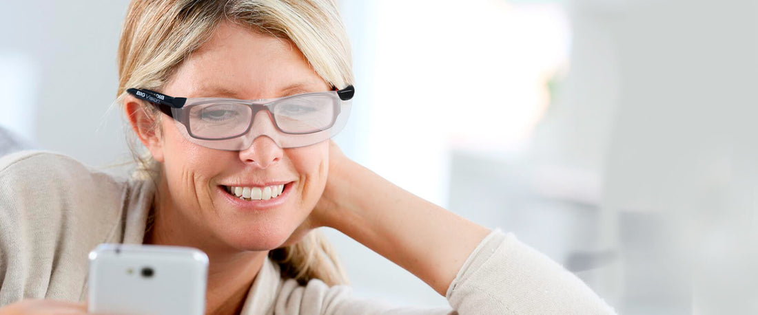 Mujer usando sus Big Vision frente al celular.