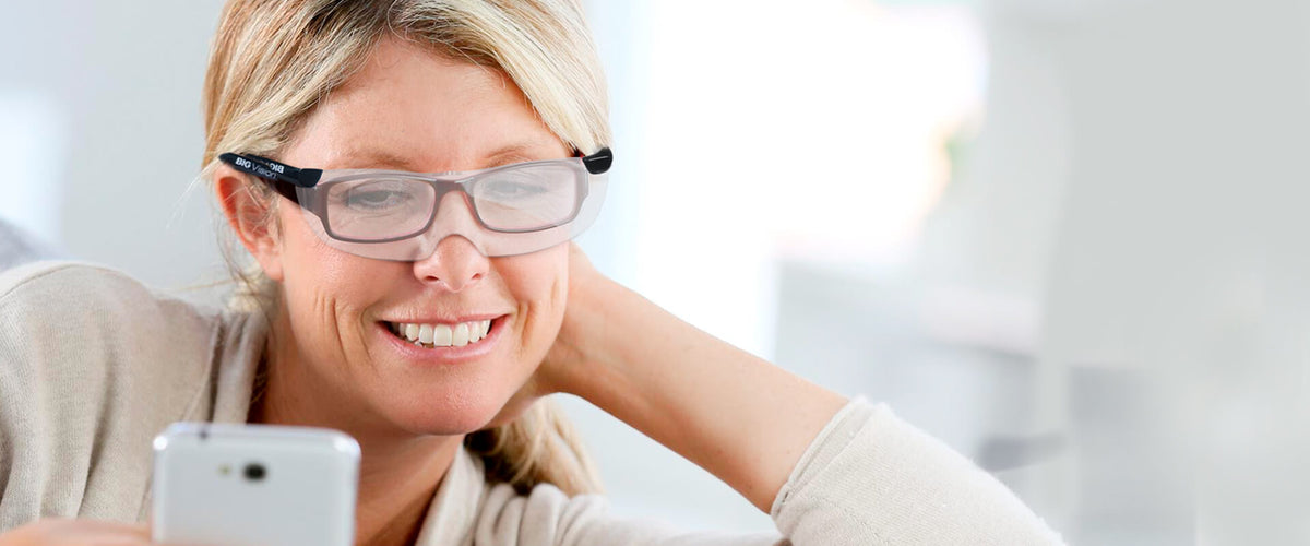 Mujer usando sus Big Vision frente al celular.