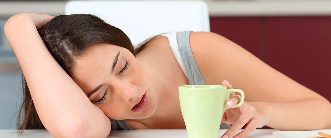 Mujer con narcolepsia durmiendo mientras toma café.