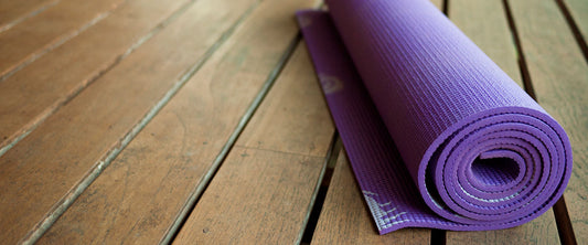 Tapete de yoga para la cintura, enrollado en el piso.